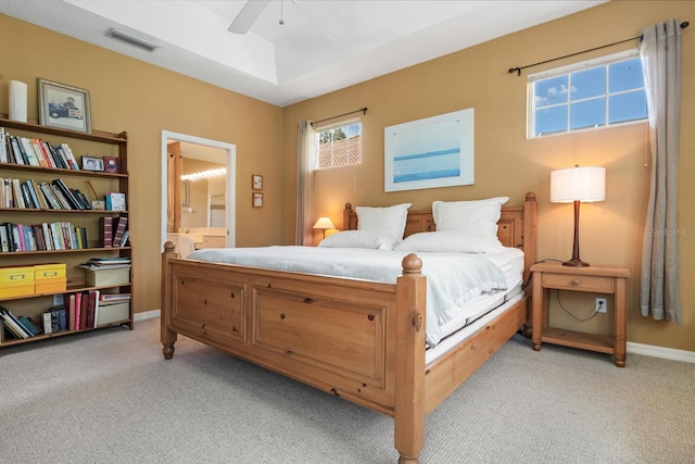 4374 Mirabella Cir, Bradenton, FL 34210 - bedroom with light colored carpet, a raised ceiling, ensuite bath, and a ceiling fan