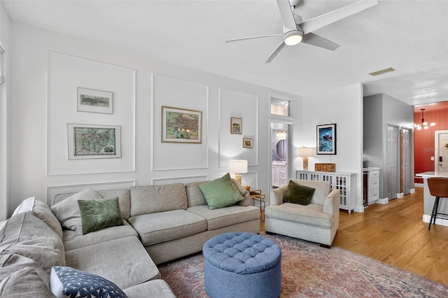 13640 2nd Ave E, Bradenton, FL 34212 - living room featuring light wood-style flooring, a ceiling fan, and a chandelier
