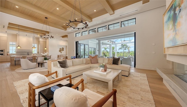 15315 Anchorage Pl, Lakewood Ranch, FL 34202 - living room featuring a wooden ceiling with exposed beams, a chandelier, light wood-style floors, a towering ceiling, and recessed lighting
