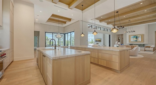 15315 Anchorage Pl, Lakewood Ranch, FL 34202 - kitchen with light brown cabinetry, a spacious island, a chandelier, open floor plan, and a wooden ceiling with exposed beams