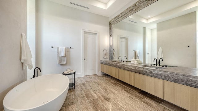 15315 Anchorage Pl, Lakewood Ranch, FL 34202 - bathroom with a soaking tub, double vanity, and a tray ceiling