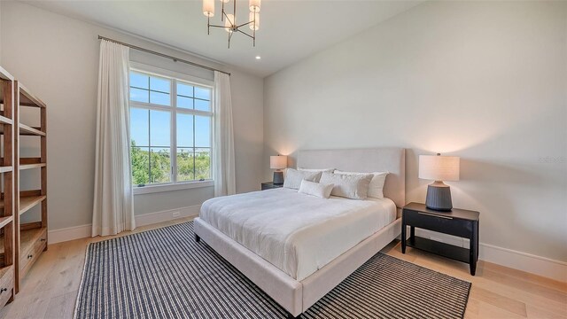15315 Anchorage Pl, Lakewood Ranch, FL 34202 - bedroom featuring light wood-style floors and a chandelier