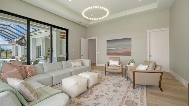15315 Anchorage Pl, Lakewood Ranch, FL 34202 - living area featuring light wood-style flooring, a chandelier, and a tray ceiling