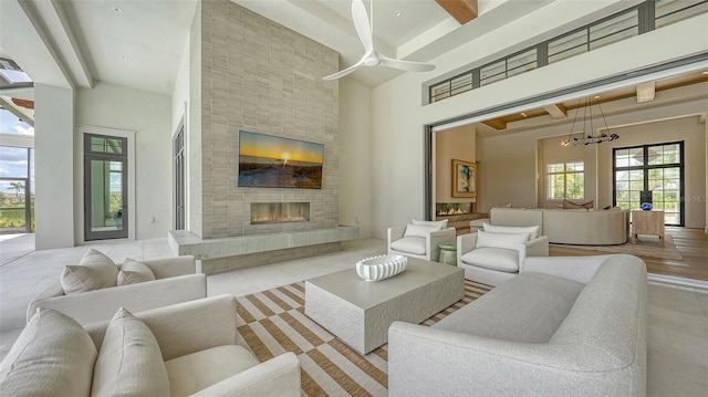 15315 Anchorage Pl, Lakewood Ranch, FL 34202 - living area with a high ceiling, a tiled fireplace, a chandelier, ceiling fan, and beamed ceiling