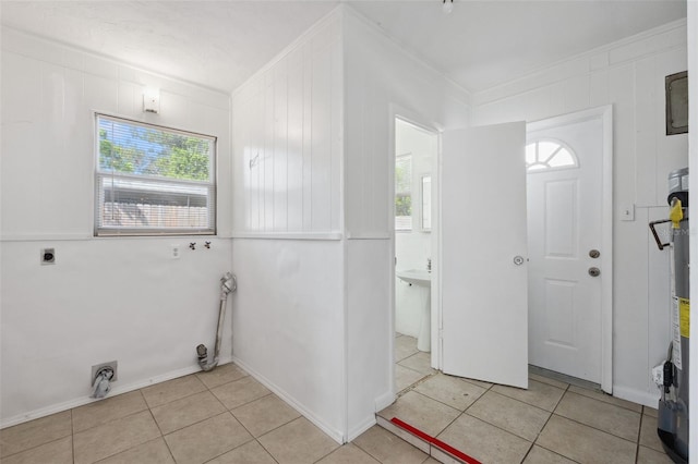 1404 Dartmouth Dr, Bradenton, FL 34207 - laundry room featuring crown molding, healthy amount of natural light, electric dryer hookup, light tile patterned floors, and water heater