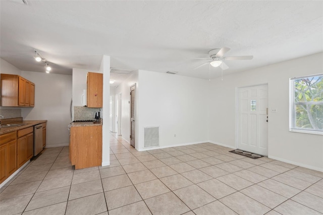 1404 Dartmouth Dr, Bradenton, FL 34207 - kitchen featuring stainless steel dishwasher, tasteful backsplash, a ceiling fan, light tile patterned floors, and brown cabinetry