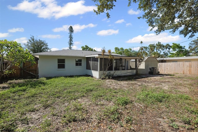 1404 Dartmouth Dr, Bradenton, FL 34207 - back of house featuring a sunroom, a fenced backyard, and a storage unit