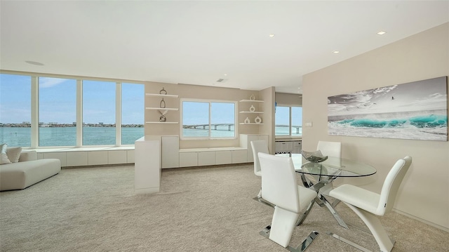 350 Golden Gate Pt Unit 61, Sarasota, FL 34236 - dining area with light carpet and a water view