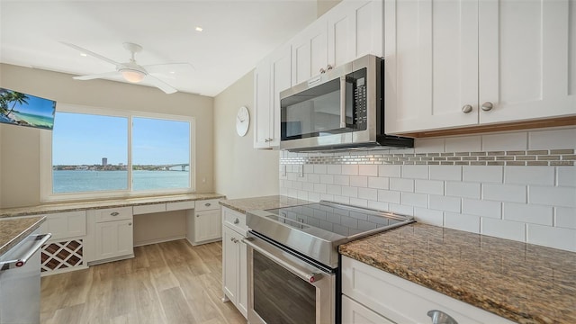 350 Golden Gate Pt Unit 61, Sarasota, FL 34236 - kitchen with stainless steel appliances, white cabinets, ceiling fan, and dark stone countertops
