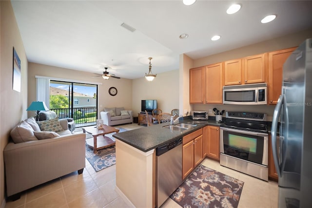4235 Overture Cir Unit 4235, Bradenton, FL 34209 - kitchen with appliances with stainless steel finishes, open floor plan, a peninsula, dark countertops, and light tile patterned floors