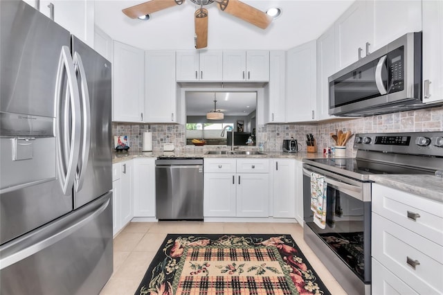5417 Champagne Unit 63, Sarasota, FL 34235 - kitchen featuring stainless steel appliances, ceiling fan, decorative backsplash, and white cabinetry