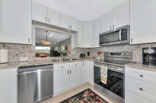 5417 Champagne Unit 63, Sarasota, FL 34235 - kitchen with appliances with stainless steel finishes, decorative backsplash, white cabinetry, and light stone counters