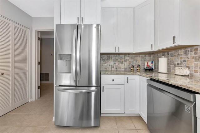 5417 Champagne Unit 63, Sarasota, FL 34235 - kitchen with stainless steel appliances, light tile patterned floors, white cabinetry, and light stone countertops