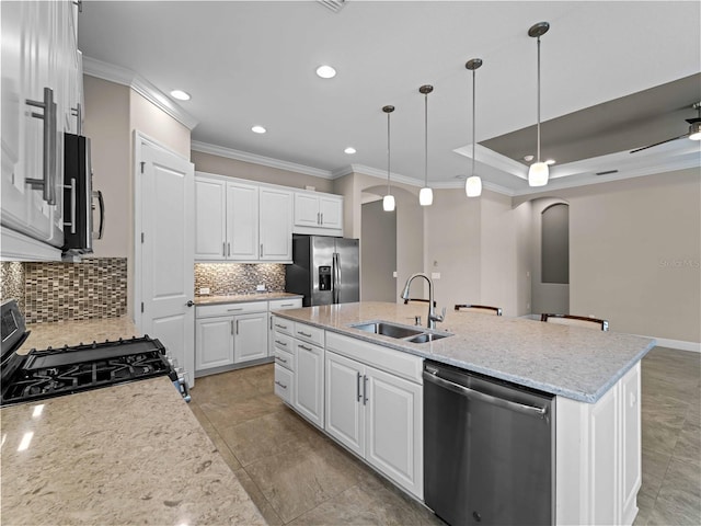 5364 Salcano St, Sarasota, FL 34238 - kitchen featuring stainless steel appliances, arched walkways, ornamental molding, a center island with sink, and decorative backsplash