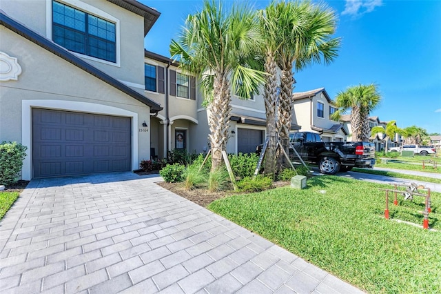 15164 Sunny Day Dr, Bradenton, FL 34211 - view of front of home featuring a garage, stucco siding, decorative driveway, and a residential view