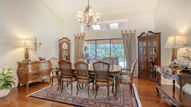 7426 Weeping Willow Blvd, Sarasota, FL 34241 - dining area featuring a chandelier, wood finished floors, and high vaulted ceiling