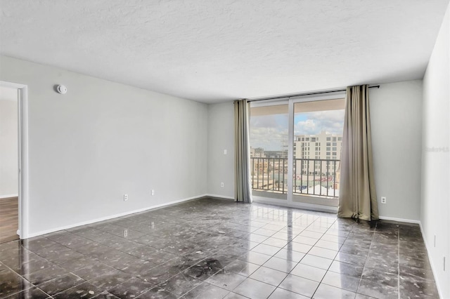 101 S Gulfstream Ave Unit 15C, Sarasota, FL 34236 - unfurnished room featuring a wall of windows, a textured ceiling, a smoke detector, and tile patterned floors