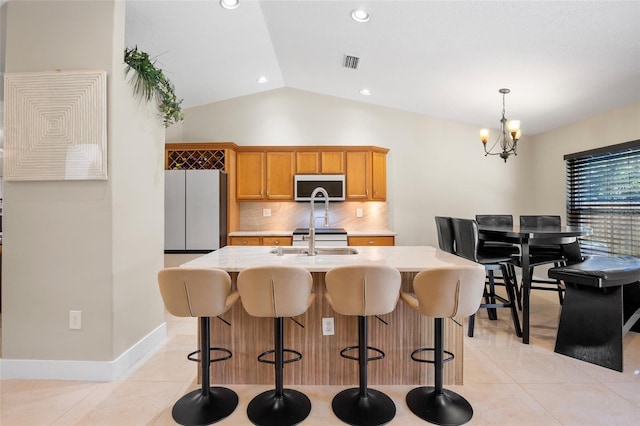 2761 Feiffer Cir, Sarasota, FL 34235 - kitchen featuring white microwave, freestanding refrigerator, light countertops, decorative backsplash, and vaulted ceiling