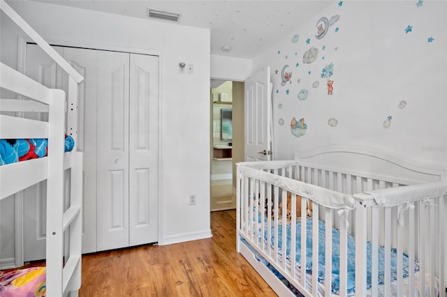 2761 Feiffer Cir, Sarasota, FL 34235 - bedroom with wood finished floors, a closet, and a nursery area