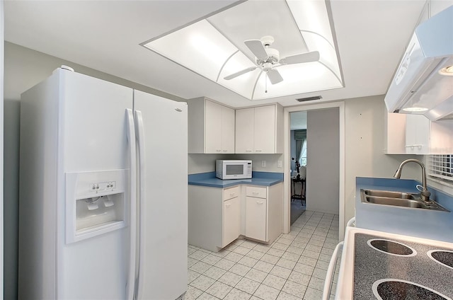 3641 Somerville Dr Unit 1506, Sarasota, FL 34232 - kitchen with white appliances, light tile patterned floors, ceiling fan, exhaust hood, and white cabinetry