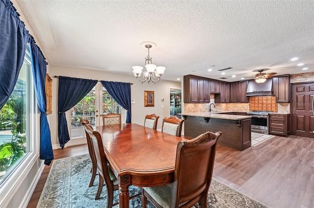 1509 Shadow Ridge Cir, Sarasota, FL 34240 - dining room featuring a chandelier, a textured ceiling, light wood-style flooring, recessed lighting, and a ceiling fan