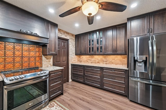 1509 Shadow Ridge Cir, Sarasota, FL 34240 - kitchen featuring appliances with stainless steel finishes, backsplash, dark brown cabinets, light wood-style floors, and ceiling fan