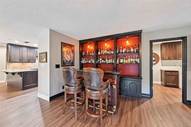 1509 Shadow Ridge Cir, Sarasota, FL 34240 - indoor dry bar with wood finished floors, a textured ceiling, and backsplash