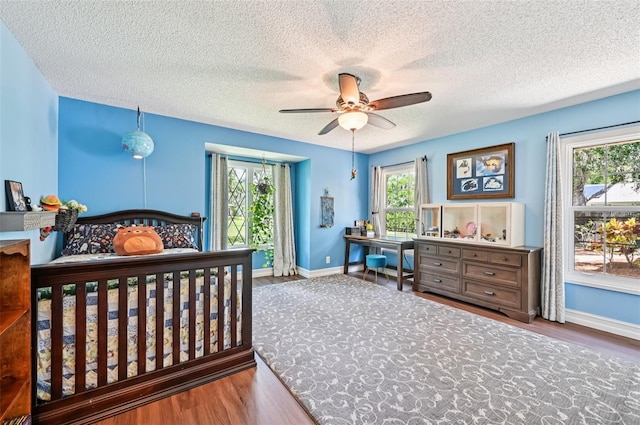 1509 Shadow Ridge Cir, Sarasota, FL 34240 - bedroom featuring wood finished floors, a textured ceiling, and a ceiling fan