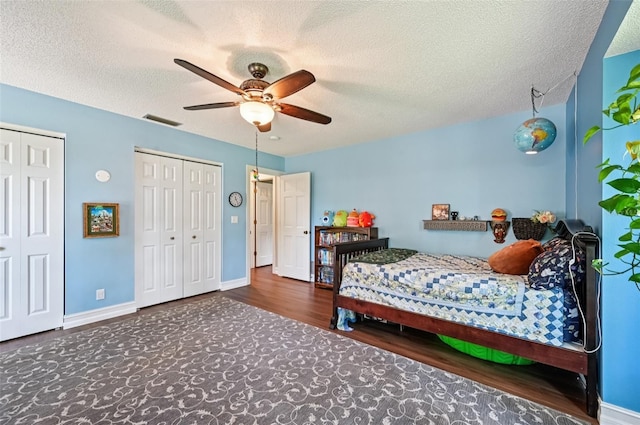 1509 Shadow Ridge Cir, Sarasota, FL 34240 - bedroom with multiple closets, wood finished floors, a textured ceiling, and a ceiling fan