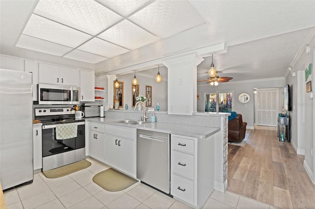 2415 Bayshore Gardens Pkwy Unit 2, Bradenton, FL 34207 - kitchen with appliances with stainless steel finishes, a peninsula, a ceiling fan, white cabinetry, and light countertops