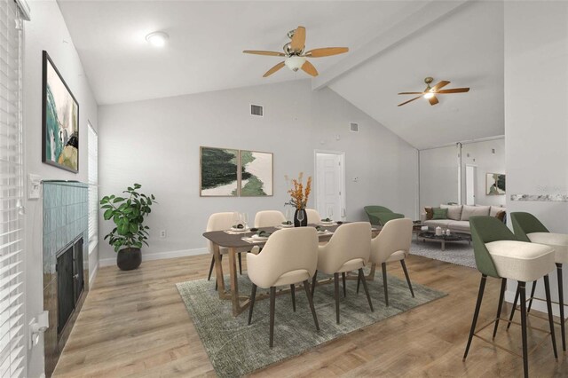 4333 Trails Dr Unit 10-1, Sarasota, FL 34232 - dining space with high vaulted ceiling, a fireplace, ceiling fan, beam ceiling, and light wood-type flooring
