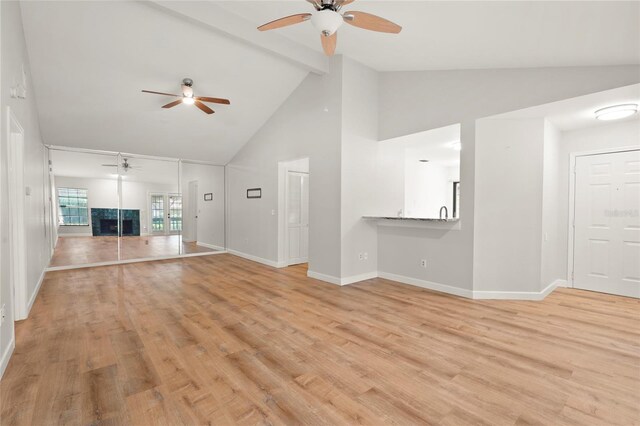 4333 Trails Dr Unit 10-1, Sarasota, FL 34232 - unfurnished living room with ceiling fan, high vaulted ceiling, beamed ceiling, light wood-style flooring, and a fireplace