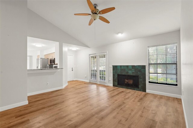 4333 Trails Dr Unit 10-1, Sarasota, FL 34232 - unfurnished living room with vaulted ceiling, a ceiling fan, wood finished floors, and a tile fireplace