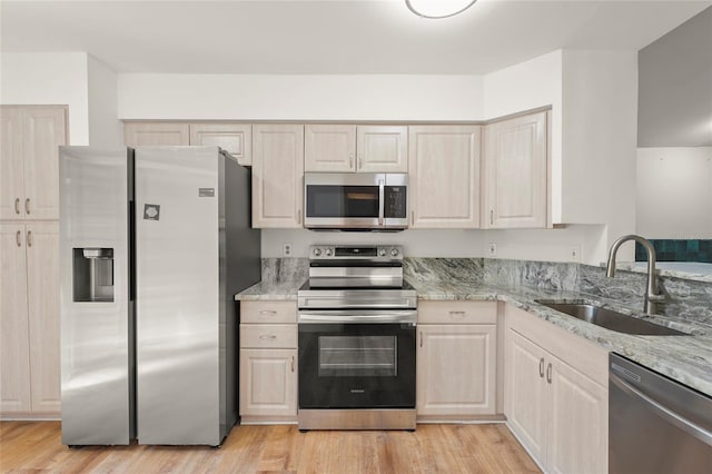 4333 Trails Dr Unit 10-1, Sarasota, FL 34232 - kitchen with appliances with stainless steel finishes, light wood-style floors, and light stone counters