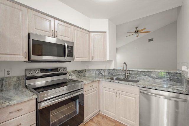 4333 Trails Dr Unit 10-1, Sarasota, FL 34232 - kitchen with stainless steel appliances, light brown cabinetry, a ceiling fan, light stone countertops, and lofted ceiling