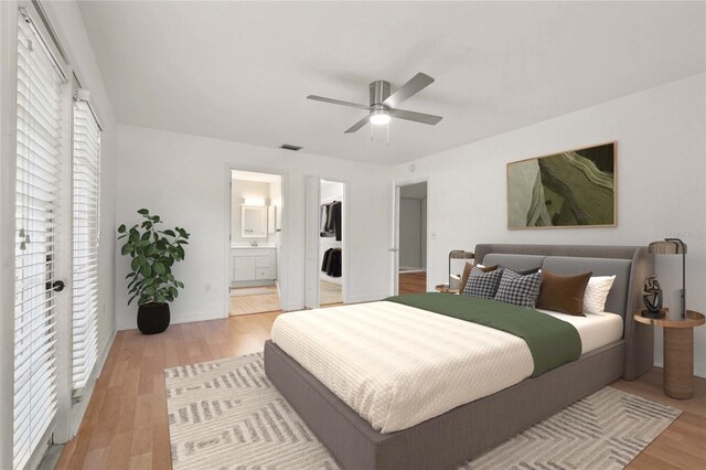 4333 Trails Dr Unit 10-1, Sarasota, FL 34232 - bedroom with light wood-type flooring, connected bathroom, ceiling fan, and a walk in closet