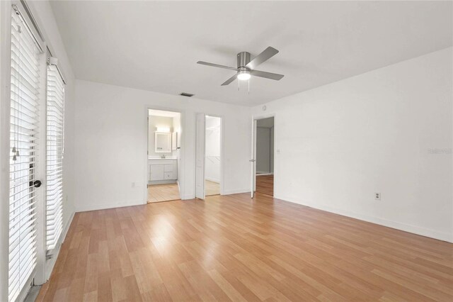 4333 Trails Dr Unit 10-1, Sarasota, FL 34232 - unfurnished bedroom with light wood finished floors, ensuite bathroom, ceiling fan, and a walk in closet