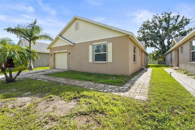 3362 Howell Pl, Sarasota, FL 34232 - view of front of home with a garage, stucco siding, driveway, and a front lawn