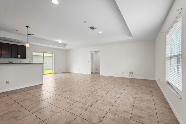 3362 Howell Pl, Sarasota, FL 34232 - unfurnished living room with light tile patterned flooring, a tray ceiling, and recessed lighting
