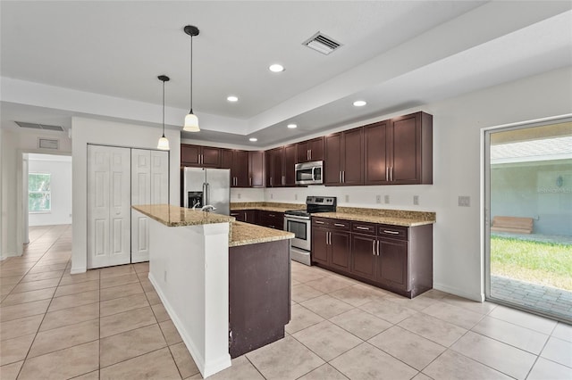 3362 Howell Pl, Sarasota, FL 34232 - kitchen featuring stainless steel appliances, light tile patterned floors, dark brown cabinetry, light stone counters, and decorative light fixtures