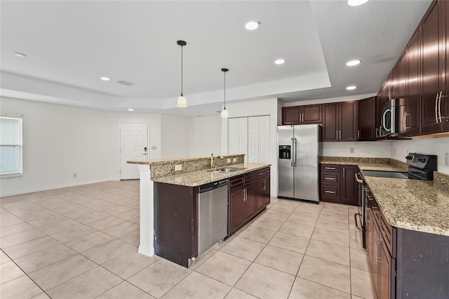 3362 Howell Pl, Sarasota, FL 34232 - kitchen featuring appliances with stainless steel finishes, a raised ceiling, light tile patterned floors, recessed lighting, and an island with sink