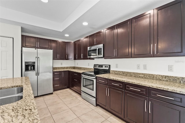 3362 Howell Pl, Sarasota, FL 34232 - kitchen with appliances with stainless steel finishes, recessed lighting, light tile patterned floors, light stone counters, and dark brown cabinets