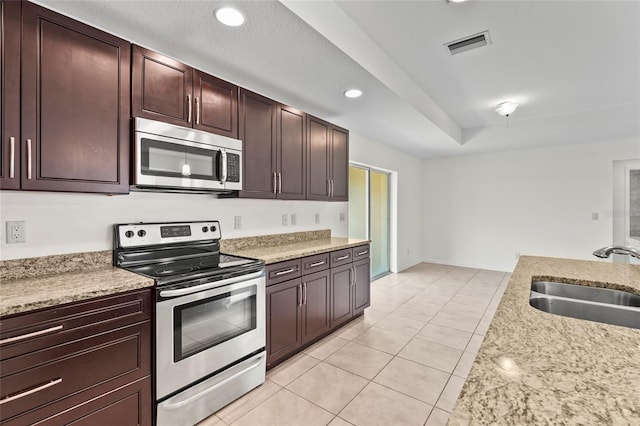 3362 Howell Pl, Sarasota, FL 34232 - kitchen featuring stainless steel appliances, light tile patterned floors, recessed lighting, dark brown cabinets, and light stone countertops