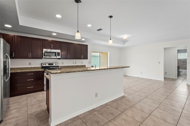 3362 Howell Pl, Sarasota, FL 34232 - kitchen with appliances with stainless steel finishes, a raised ceiling, light tile patterned floors, recessed lighting, and hanging light fixtures