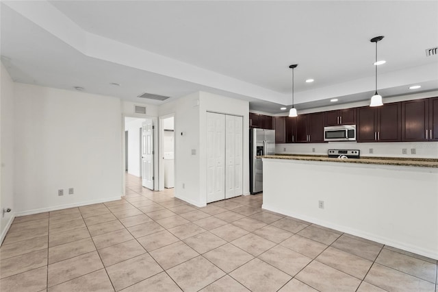 3362 Howell Pl, Sarasota, FL 34232 - kitchen with stainless steel appliances, recessed lighting, dark brown cabinets, light tile patterned flooring, and a tray ceiling