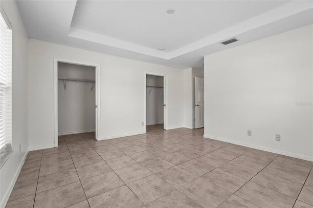 3362 Howell Pl, Sarasota, FL 34232 - unfurnished bedroom featuring two closets, a raised ceiling, and light tile patterned floors