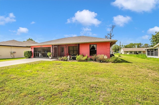 4145 W Price Blvd, North Port, FL 34286 - view of front of house with an attached garage, driveway, a sunroom, and a front lawn