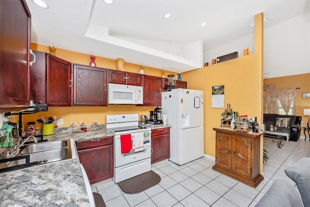 4145 W Price Blvd, North Port, FL 34286 - kitchen with white appliances, dark brown cabinets, open floor plan, light tile patterned floors, and recessed lighting