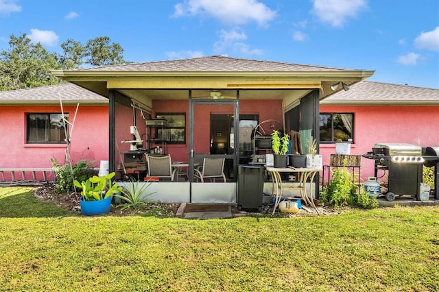 4145 W Price Blvd, North Port, FL 34286 - back of house featuring a sunroom, a lawn, stucco siding, and roof with shingles