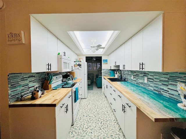 555 The Esplanade N Unit 202, Venice, FL 34285 - kitchen featuring white appliances, wooden counters, decorative backsplash, and white cabinetry